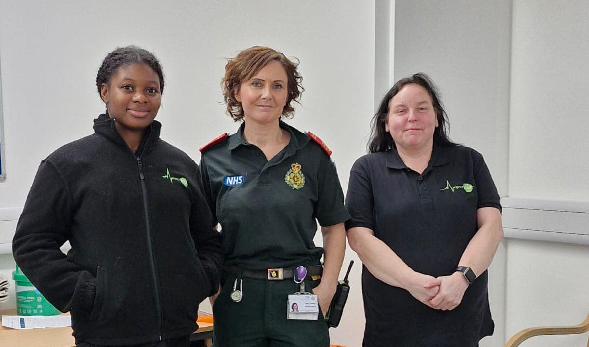 Two women in First Stop uniform with an NHS worker